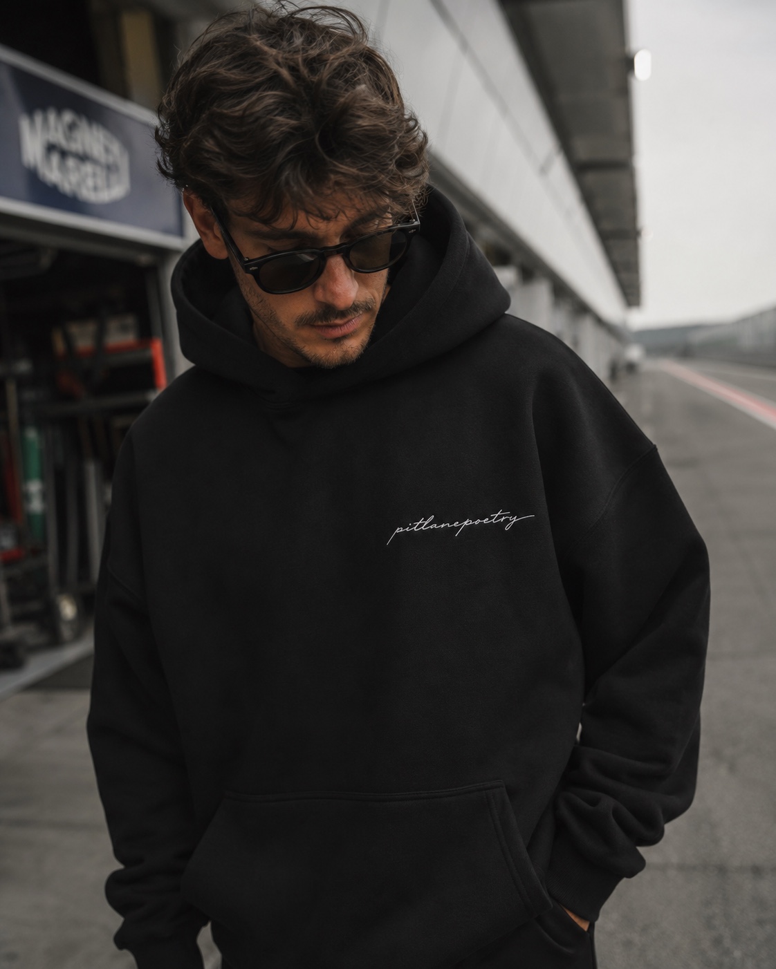 Front view of the PITLANEPOETRY hoodie on the pit lane